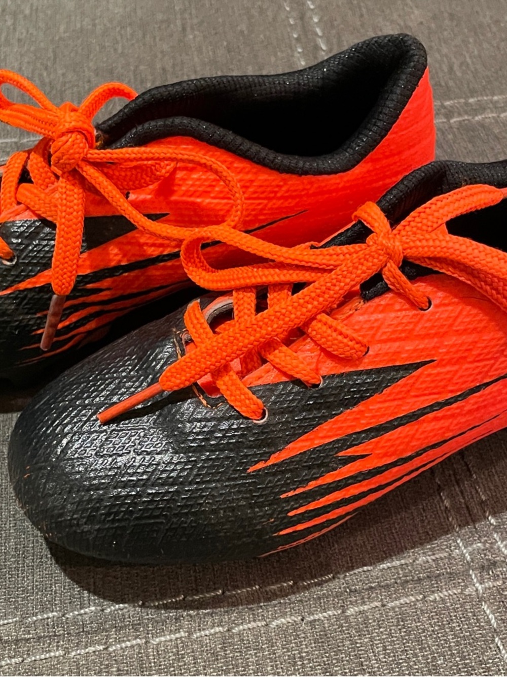 Kids Black and Orange Athletic Cleats - Bright Orange Accent